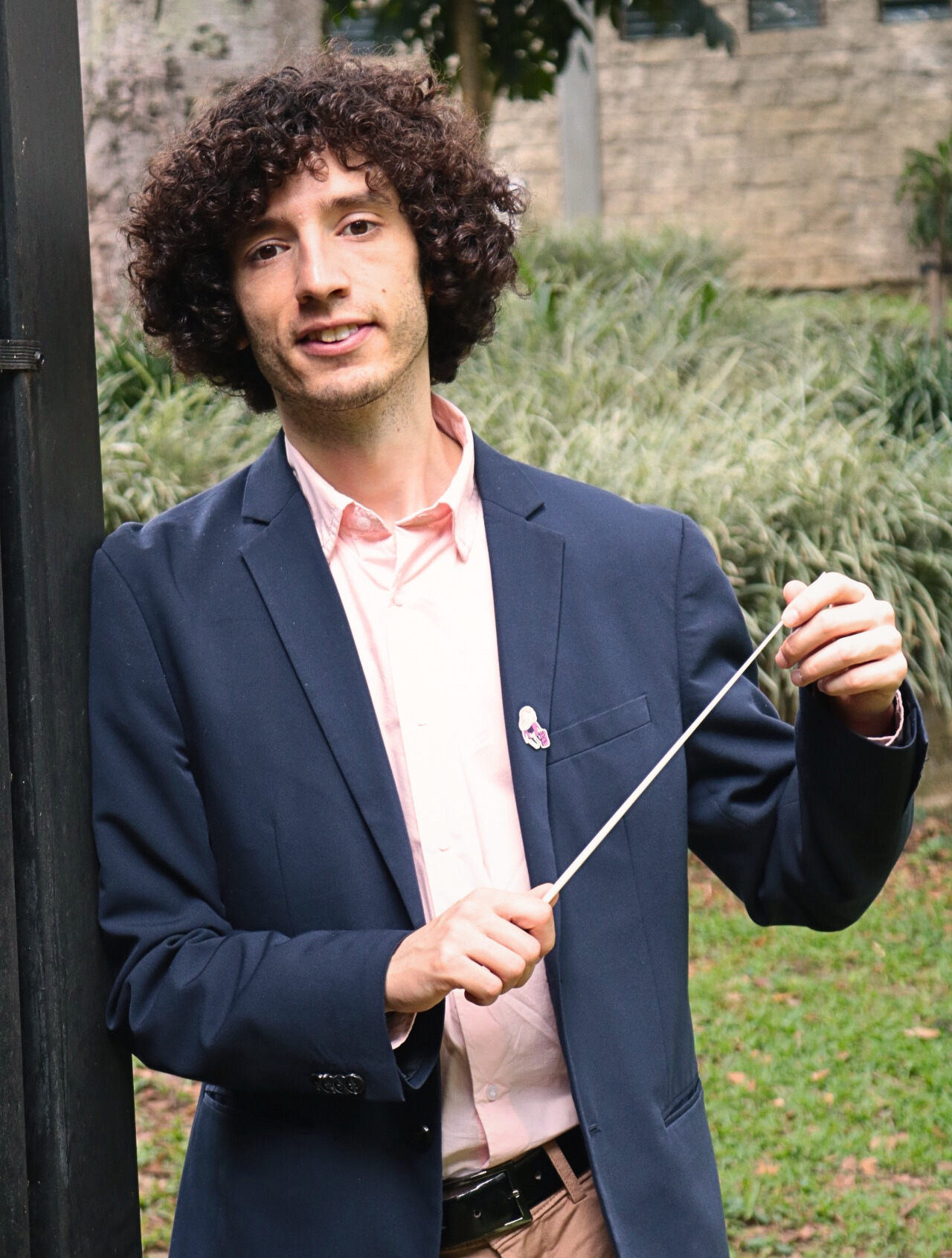 Tami Daniel Rueda Blanco, director de orquesta, sosteniendo su batuta durante una entrevista en exteriores.