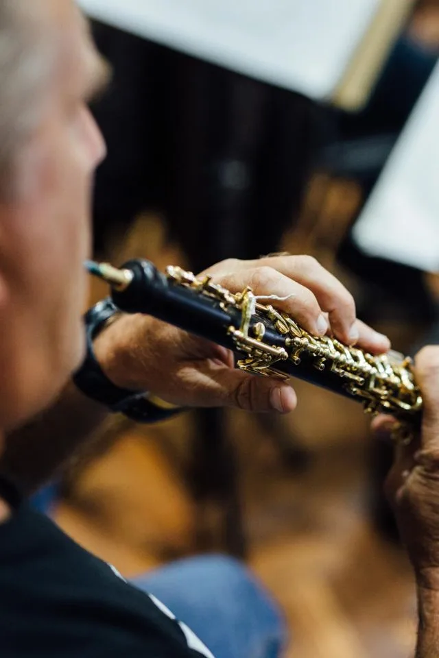 Músico de la Orquesta Filarmónica de Medellín afinando o tocando un oboe en ensayo o concierto