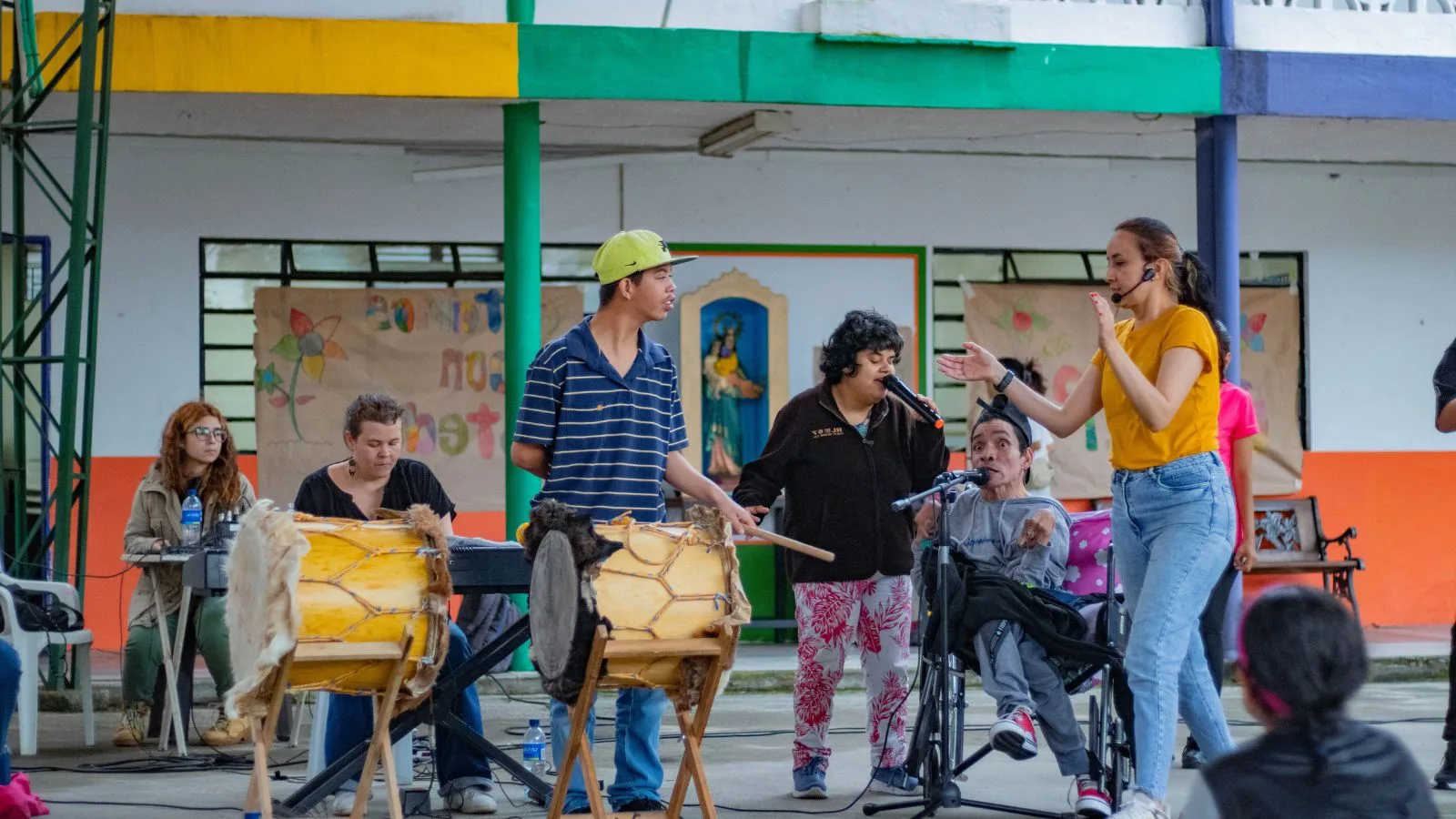 Personas con discapacidad y talleristas participando en un programa social de la Orquesta Filarmónica de Medellín, tocando instrumentos y cantando en un espacio comunitario