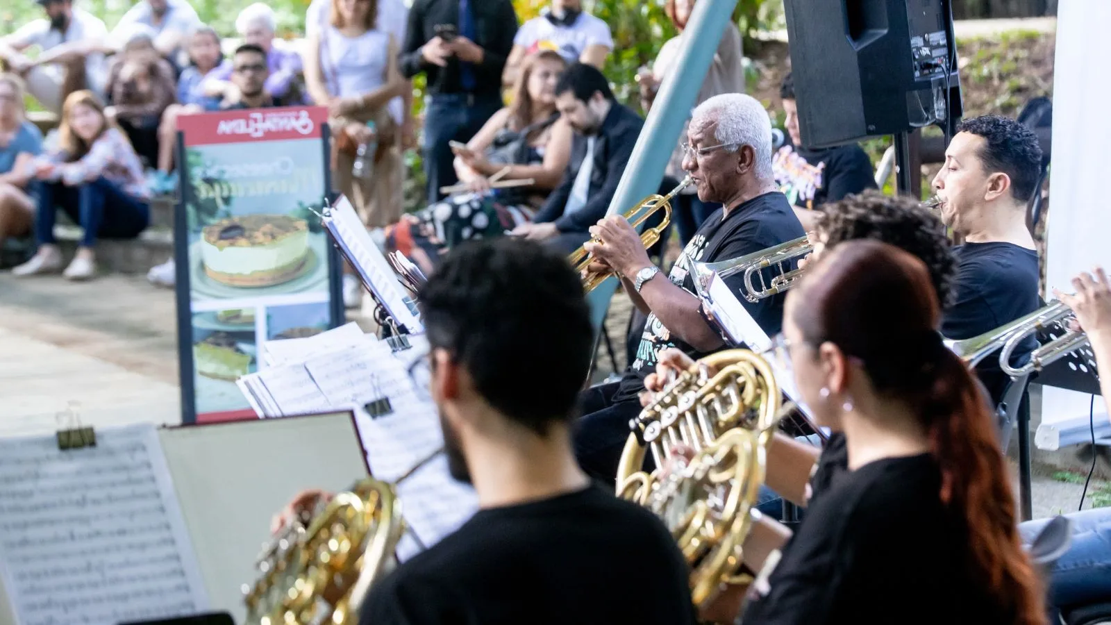 Músicos de la Orquesta Filarmónica de Medellín interpretando al aire libre frente a un público atento