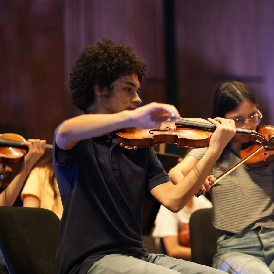 Juan Andrés tocando el violín durante un ensayo orquestal juvenil