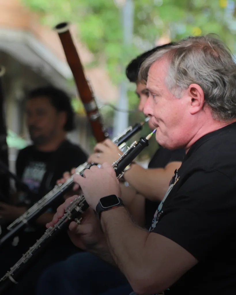 Músico de la Orquesta Filarmónica de Medellín tocando el oboe durante una retreta al aire libre.