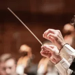 Director Paolo Bortolameolli conduciendo con intensidad a la Orquesta Filarmónica de Medellín durante la Novena Sinfonía de Mahler
