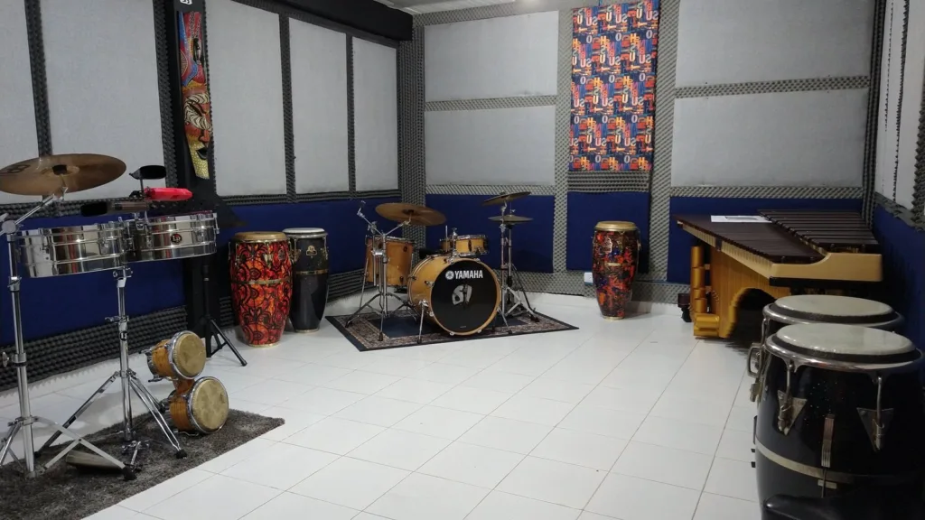 Sala de ensayo insonorizada con instrumentos de percusión como batería, congas, timbales, marimba y bongoes, en la Escuela de Música de Ciudad Bolívar.