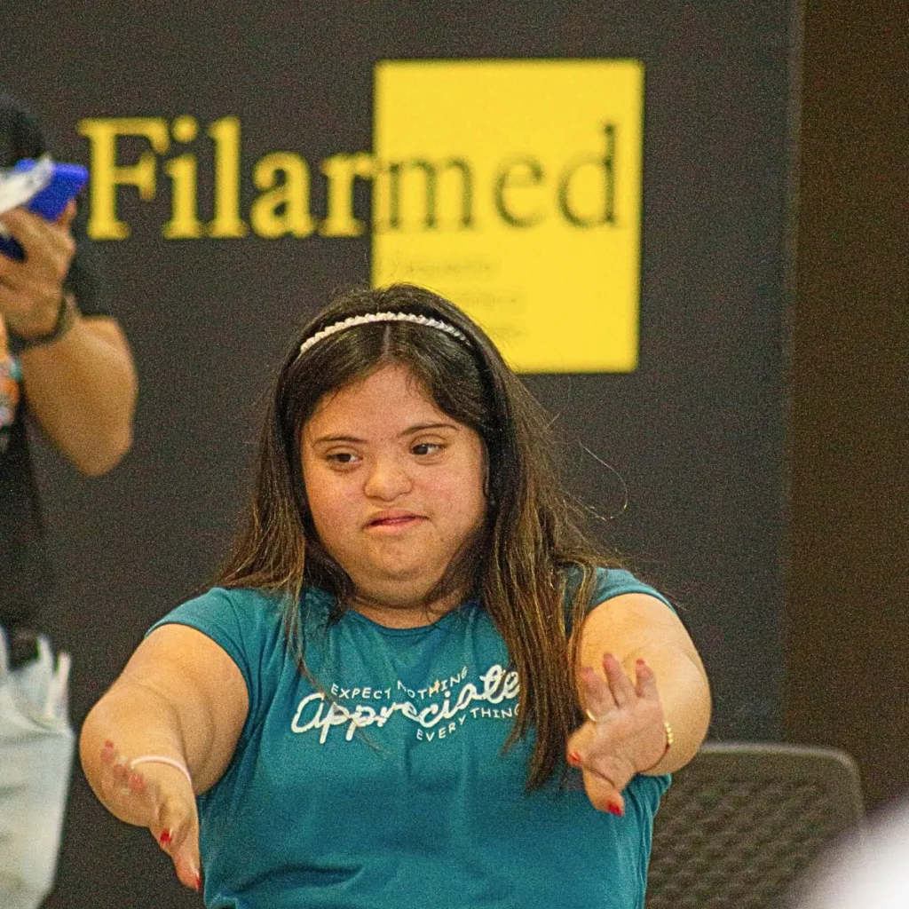 Joven con síndrome de Down realizando una actividad de expresión corporal en un taller del programa Soy Músico de la Orquesta Filarmónica de Medellín