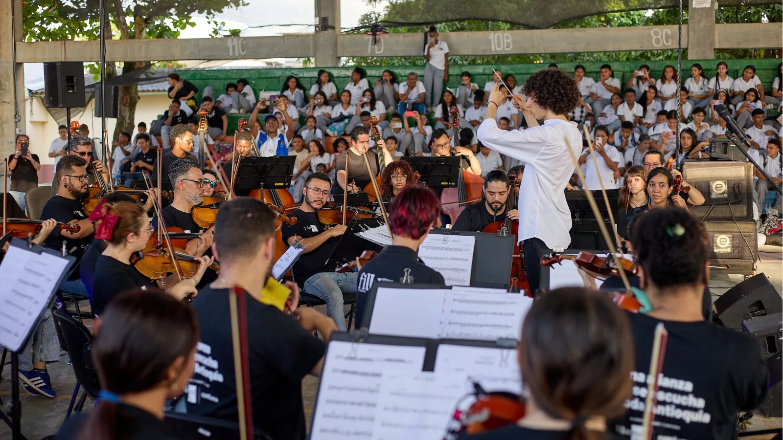 La Orquesta Filarmónica de Medellín interpreta un concierto al aire libre en Chigorodó ante estudiantes y comunidad local como parte del programa FilU.